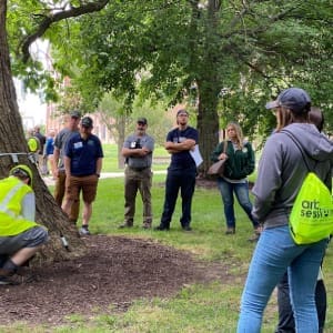 A group of people standing around a tree.