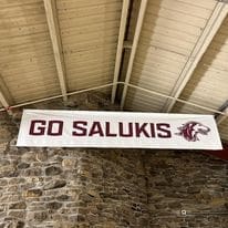 Go Salukis banner with wolf mascot.