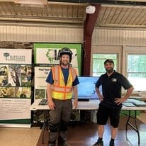 Two men at a forestry event booth.