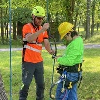 Arborist team checking ropes in bright vests.