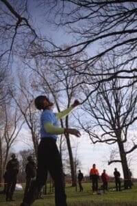 A person throws a disc in a park.
