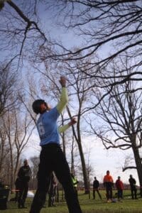 A lumberjack throws an axe at a tree.