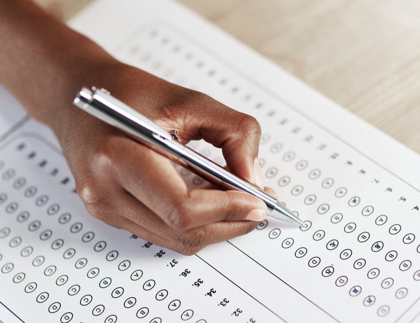 Hand filling out multiple choice test.