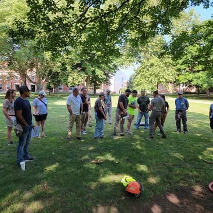 Group of people standing on grassy field.