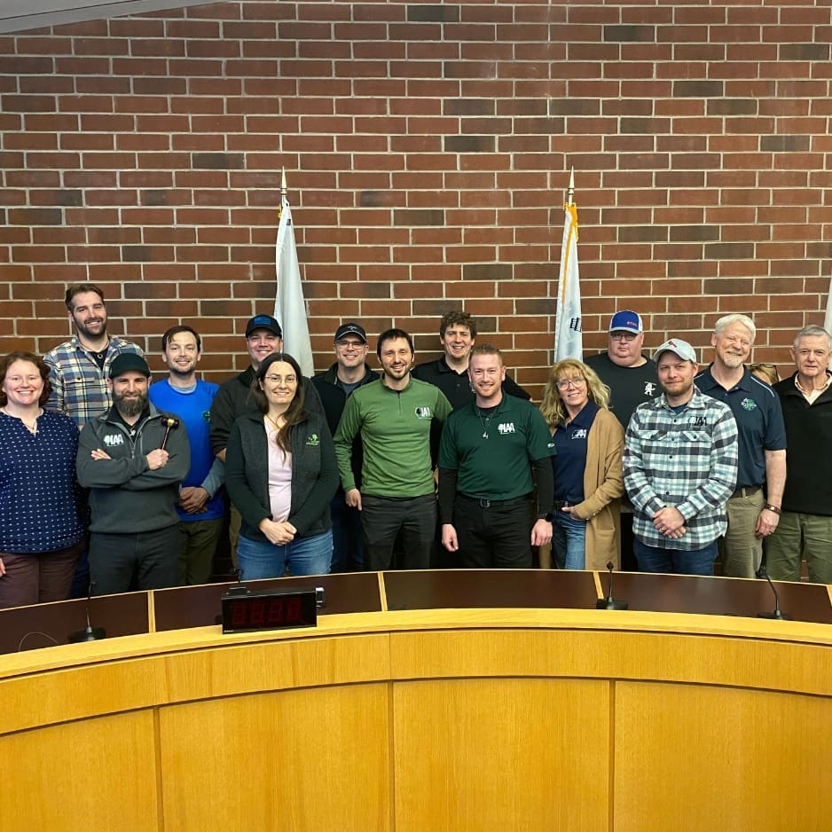 Group of people posing in front of flags.