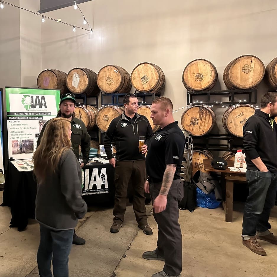 People gathered in brewery with display table.